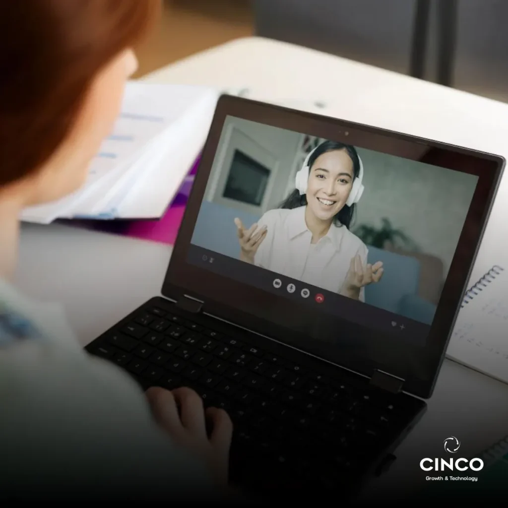 Mulher conversando com uma outra mulher que está na tela do computador.