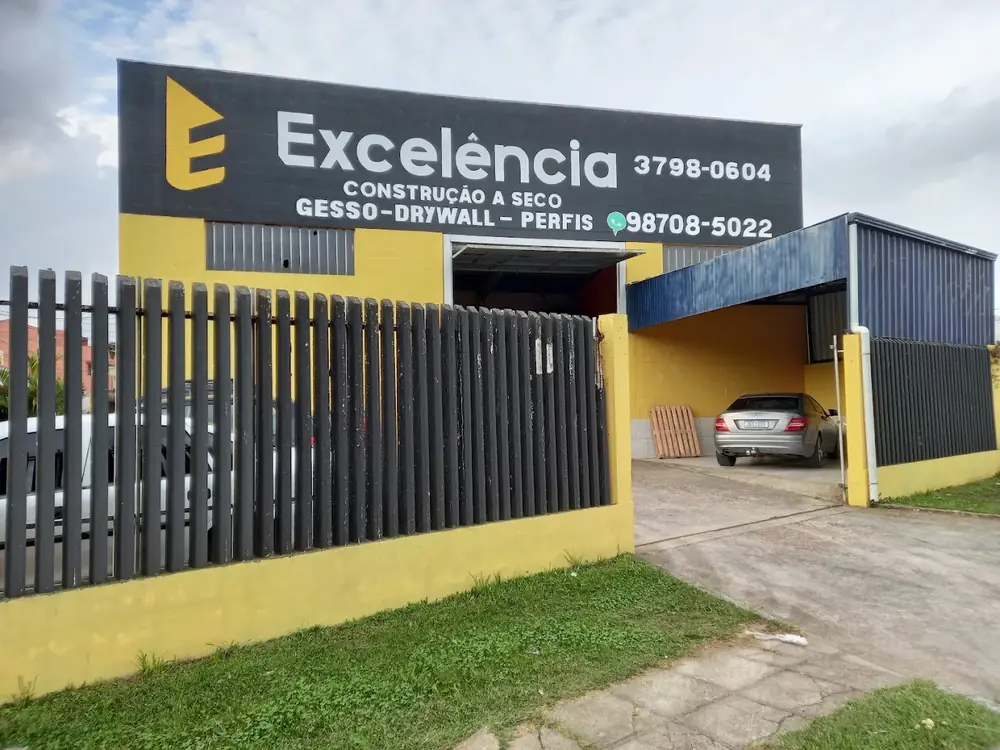 Fachada amarela, cinza e preta da Excelência Drywall