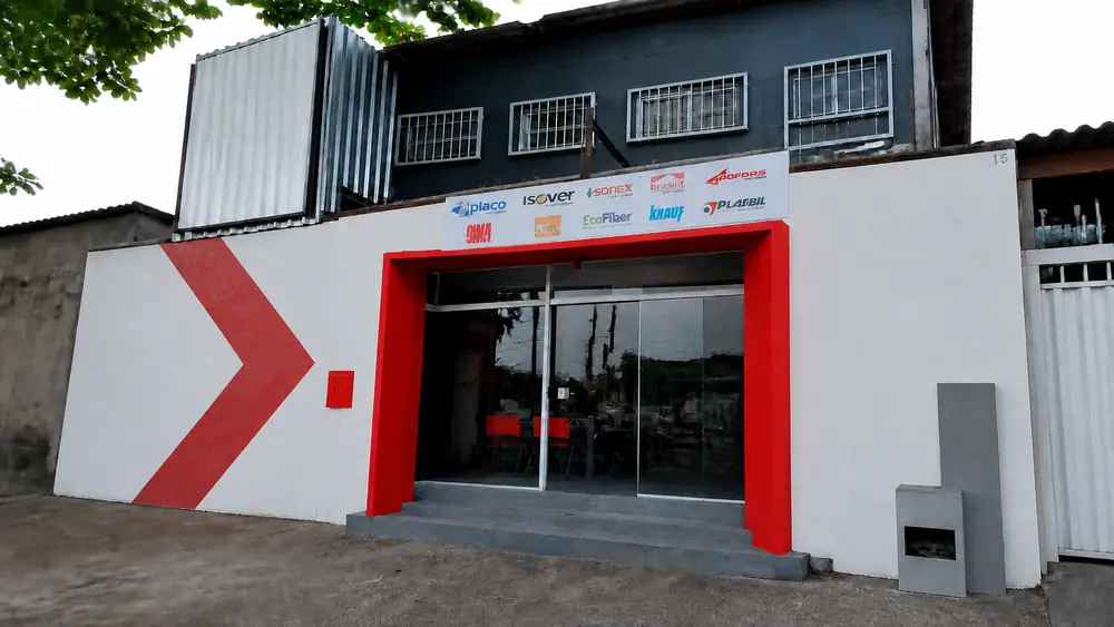 Fachada da F. Drywall Freguesia com seta vermelha pintada no muro