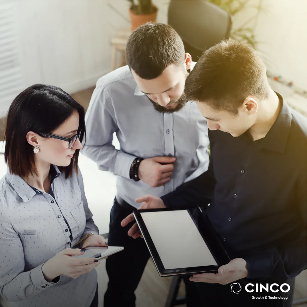 Dois homens e uma mulher olhando para a tela de um tablet